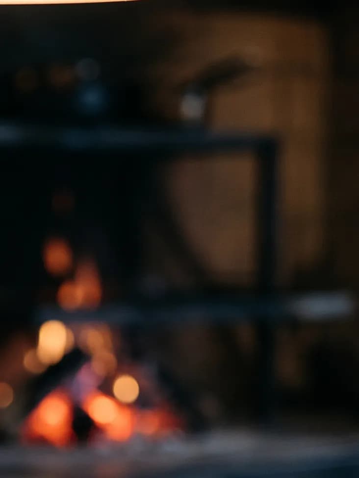 Embers glowing in the kitchen hearth behind the pass